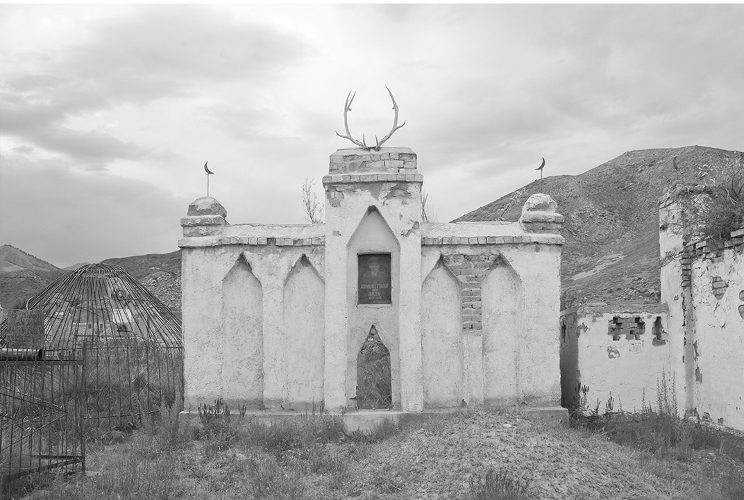 Оленьи рога украшают памятник на кладбище, также портрет оформленный с советских времен  и исламский полумесяц.