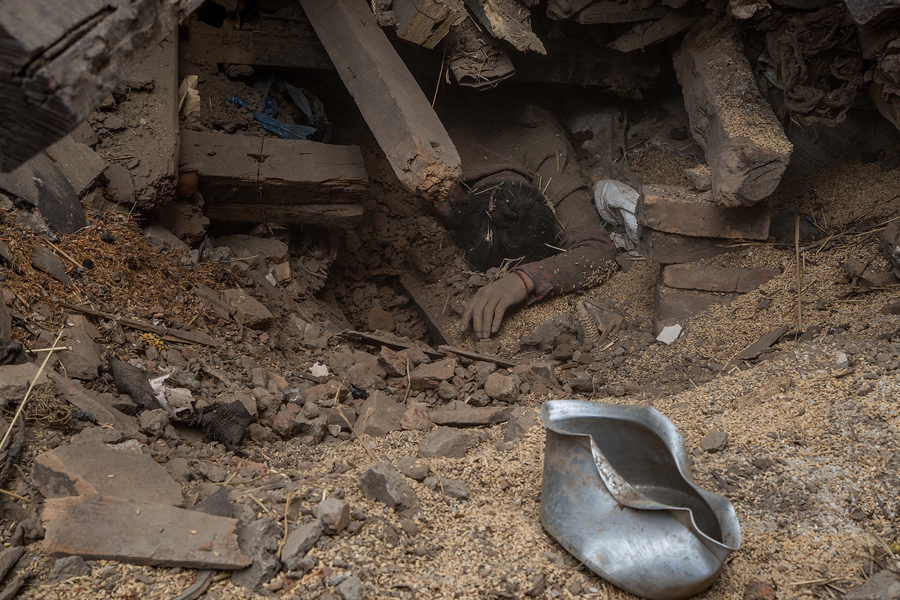 Тело жертвы землетрясения в Непале, лежит под обломками одного из разрушенных зданий г. Бхактапур.