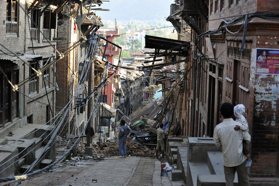 Жители смотрят на разрушенные дома в Бхактапуре, на окраине Катманду.