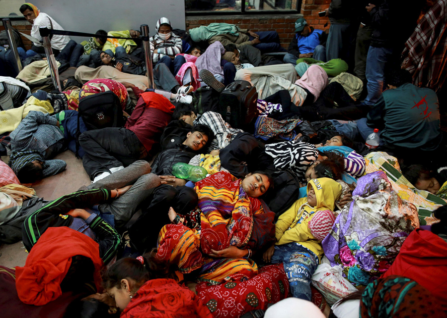 Люди спят у терминала ожидая вылета, в аэропорту в Катманду.