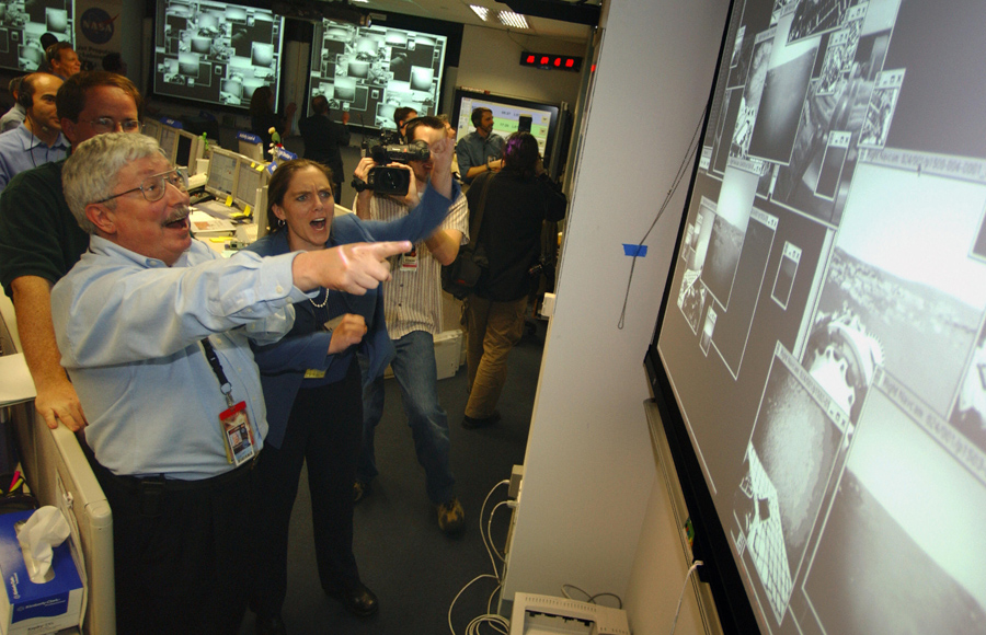 202 дней после запуска ракеты в день посадки - руководитель проекта Пит Тейсингер и менеджер Дженнифер Троспер реагируют как первые кадры прибывают в НАСА от марсохода «Оппортьюнити».