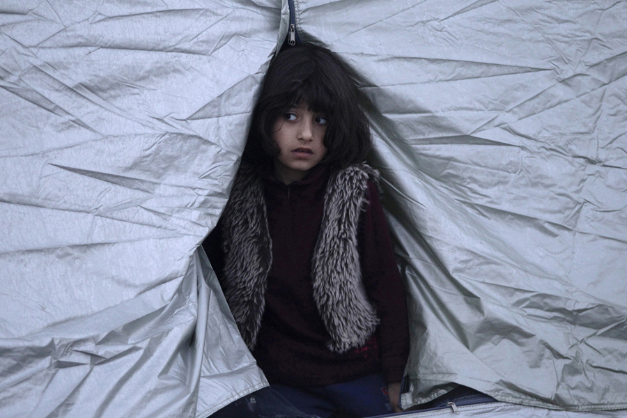 Девочка выглядывает из палатки, 1-го марта 2016 года.