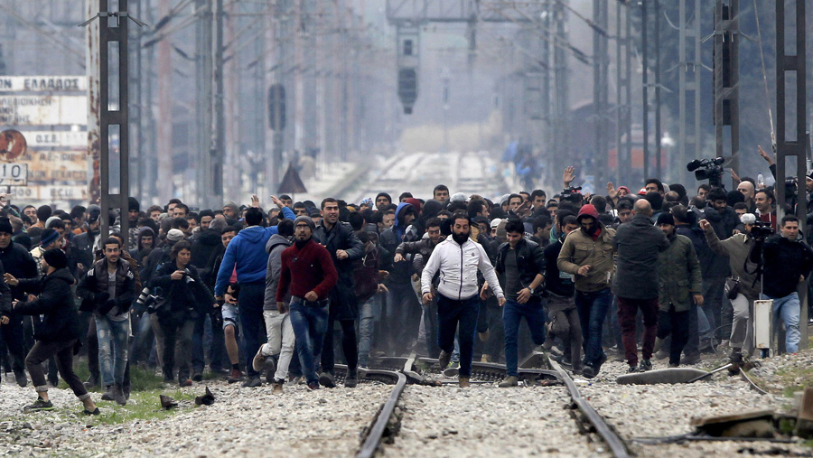 В этом снимке сделанном с македонской стороны, беженцы и мигранты в северной греческой деревни Идомени приближаются к греко-македонской границе, 29 февраля 2016 года.