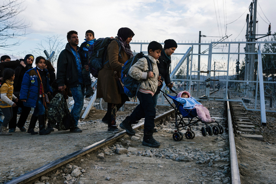 Беженцы пересекают греко-македонской границу в районе города Гевгелия 2-го марта 2016 года. Македония разрешила пустить около 250 мигрантов, более 10000 остались ждать в жалких условиях греческих чиновников и журналистов AFP.