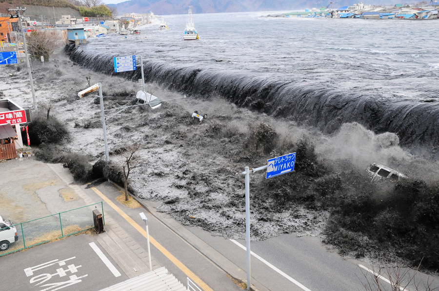 Цунами достигло города Мияко пробив дамбу и затопив улицы в префектуре Иватэ, Япония, после землетрясения магнитудой 9,0, 11 марта 2011 года.