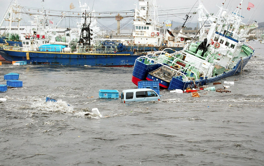 Рыбацкие лодки и корабли повреждаются волнами цунами в порту Онахама города Иваки, Северной Японии 11 марта 2011 года.