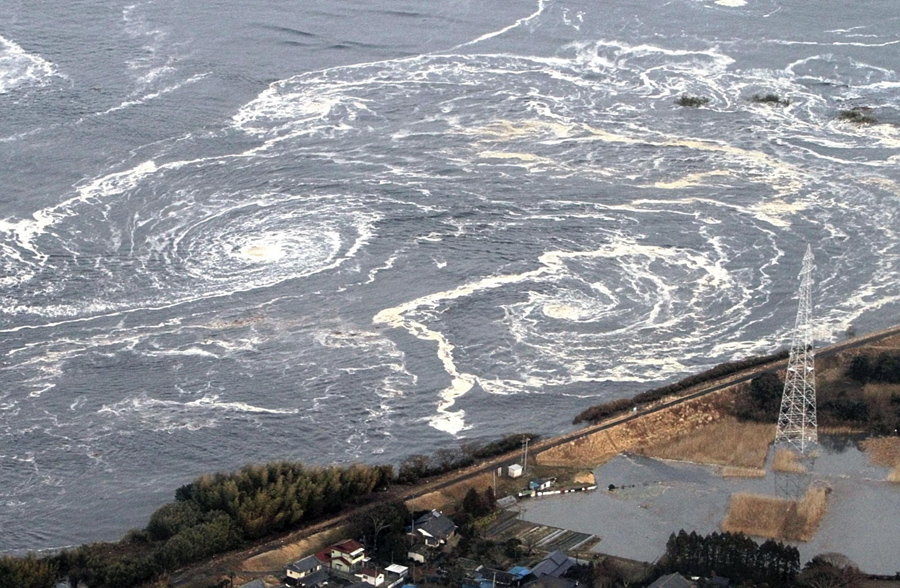 Водовороты говорят очледующих цунами и землетрясениях в городе Иваки, префектура Фукусима, 11 марта 2011 года.