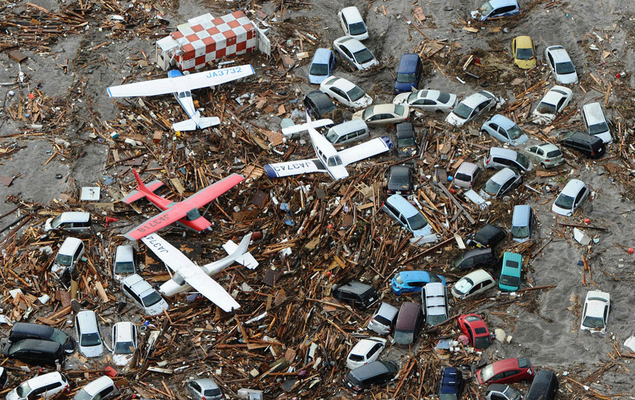 Автомобили и самолеты среди мусора в аэропорту Сендай, 11 марта 2011 года.