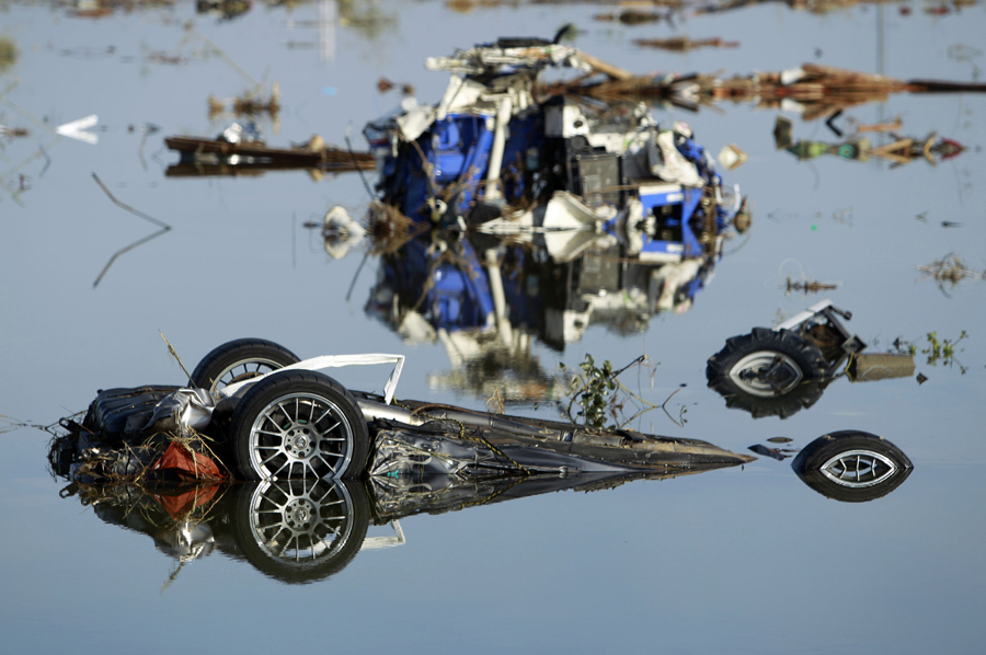 Разбитый спорткар в воде, город Сома, префектура Фукусима, Япония, 14 марта 2011 года.