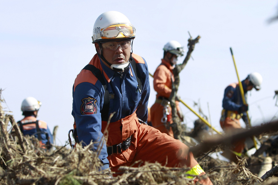 Пожарные в поисках людей, 14 марта 2011 года в Сома, префектура Фукусима, три дня после мощного землетрясения и цунами.
