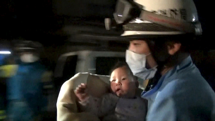 Спасение грудного ребенка из развалившегося дома, вызванного землетрясением в городе Машику, префектура Кумамото, на юге Японии, 15 апреля 2016 года.