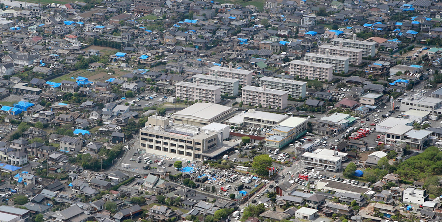Вид с воздуха показывает город Машику. Поврежденные жилые дома покрыты голубым навесом для защиты их от дождя после землетрясения, 16 апреля 2016 года.
