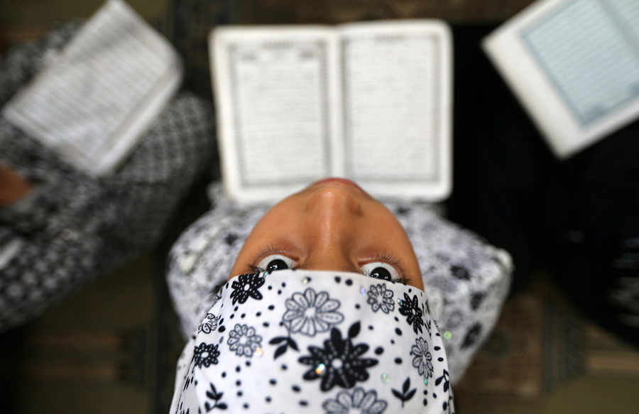 Палестинская девочка читает Коран в мечети во время Рамадана, город Рафах в южной части сектора Газа, 8 июня 2016 года.