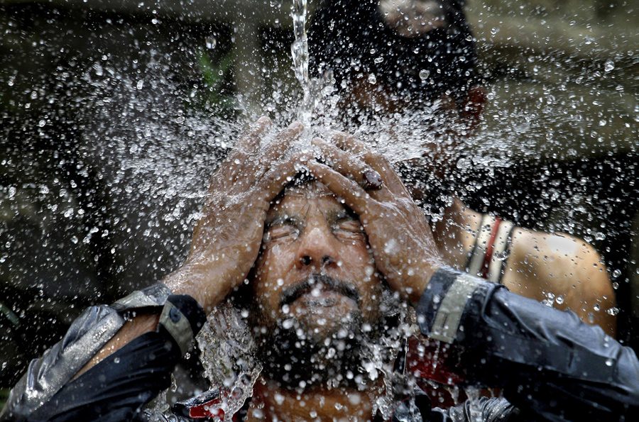 Пакистанский мужчина охлаждает себя под водой во время Рамадана, Пакистан, 7 июня 2016 года.