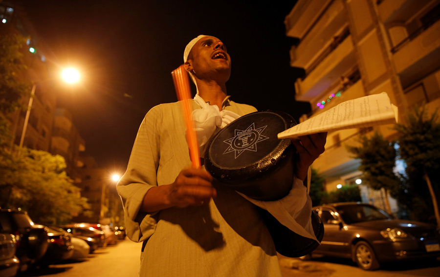 Мужчина будет жителей для предрассветной трапезы в первый день Рамадана в Каире, Египет, 6 июня 2016 года.