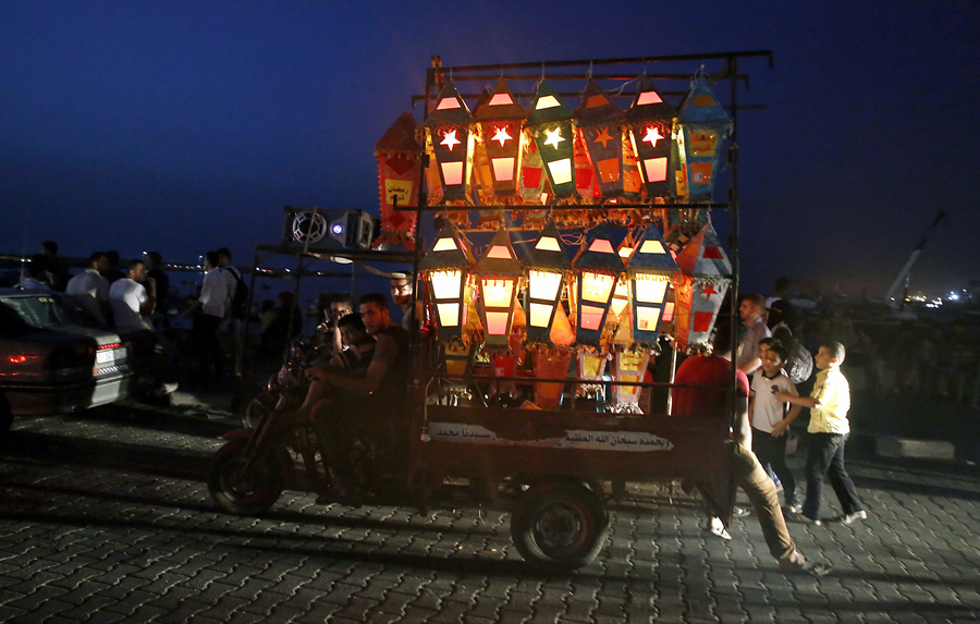 Мотоцикл с телегой едет по городу с зажженными фанариками, по случаю священного месяца Рамадан, 3 июня 2016 года.