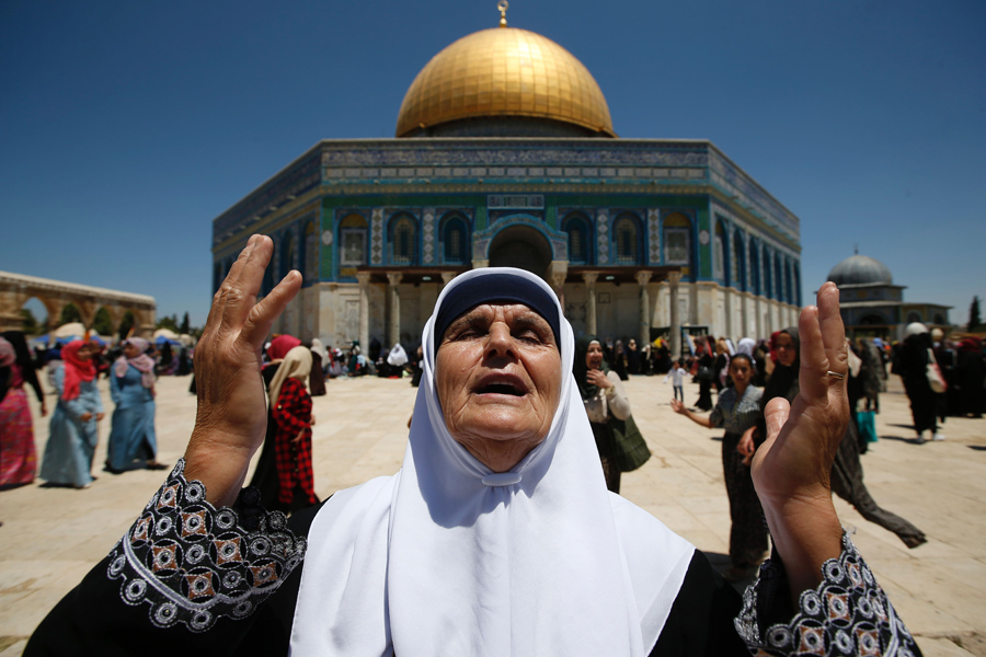 Палестинская женщина молится перед мечетью Аль-Акса в Иерусалиме для пятничных молитв священного для мусульман месяца Рамадан, 1 июля 2016 год