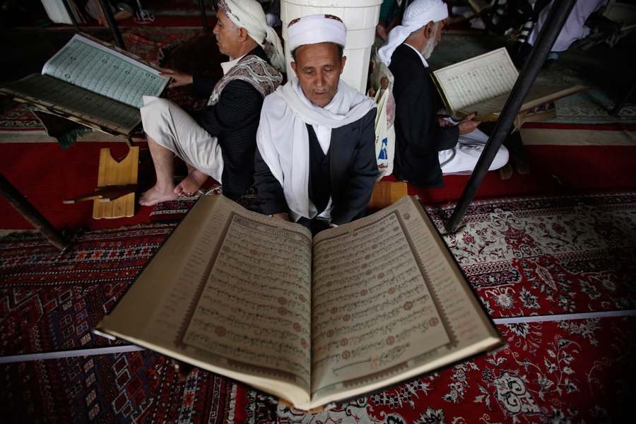 Мужчины читают священная книгу Коран в первый день месяца в Большой мечети, старого города Сана, Йемен, 6 июня 2016 года.