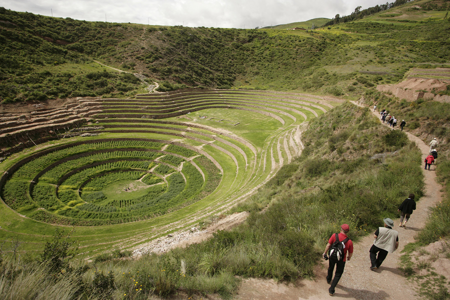 Туристы идут до террас инков Морей недалеко от города Мараш в Куско, Перу.