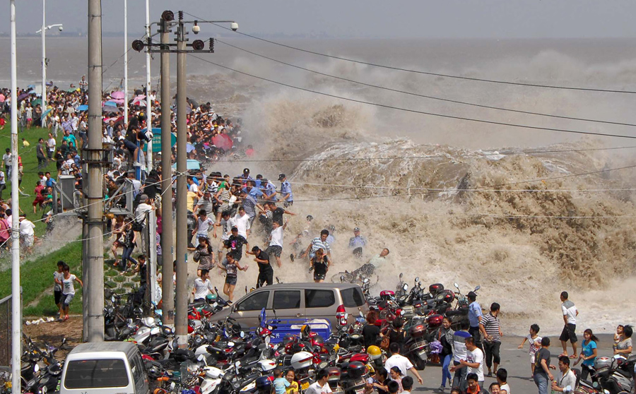 Толпа китайских туристов убегает от приливной волны вдоль реки Цяньтан в Ханчжоу, Китай, 31 августа 2011 года.