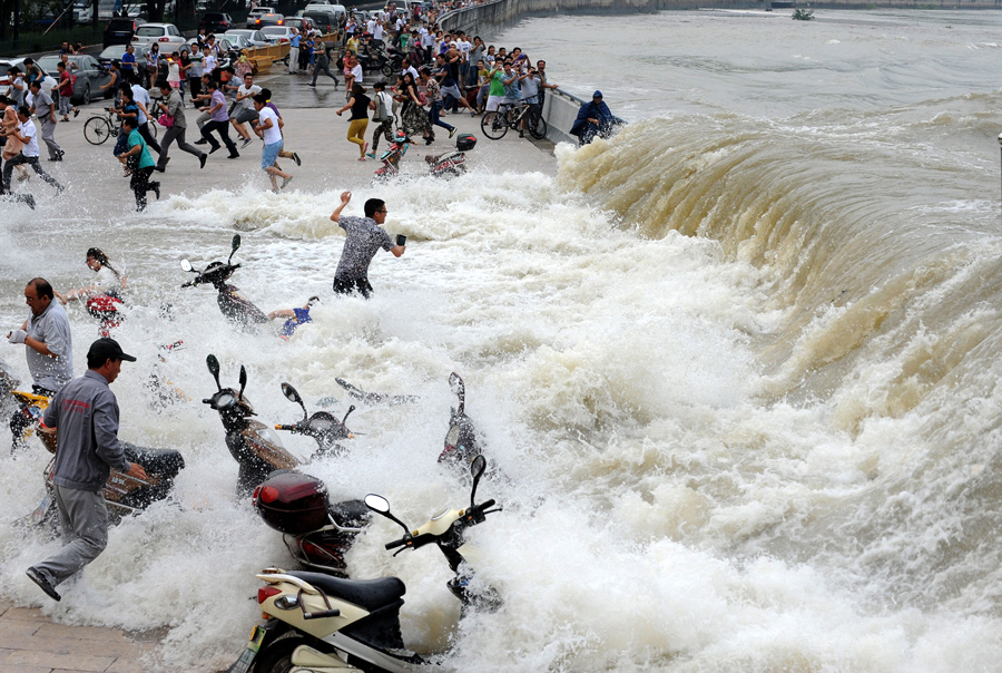 Люди охвачены огромными волнами, наблюдая приливы на реке Цяньтан, 15 августа 2014 г.