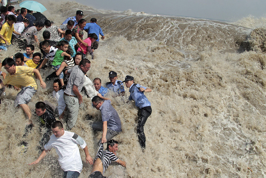 Полицейские и жители стараются держаться на ногах от приливной волны, 31 августа 2011 года. 