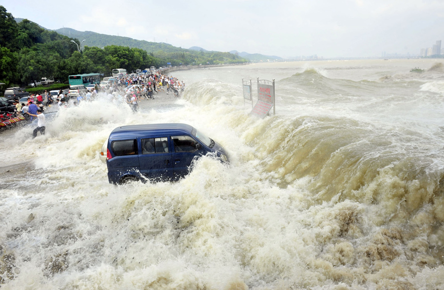 Люди убегают от приливной волны на берегу реки Цяньтан, 31 августа 2011 года.