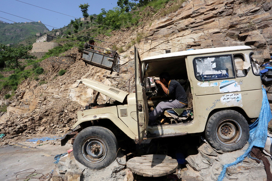Мужчина использует автомобильный двигатель для запуска канатной дороги , которая поднимает людей и грузы до горы Dhalamlam, 20 мая 2016 года.