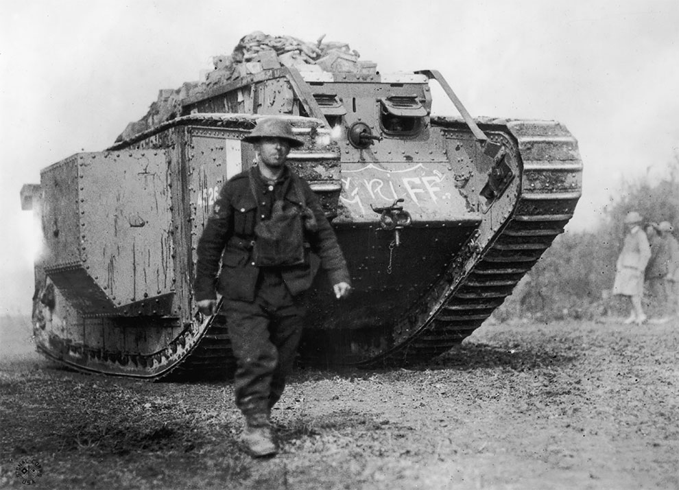 Американский солдат идет впереди тяжелого танка Mark IV (Mk IV) британского производства, 1918.