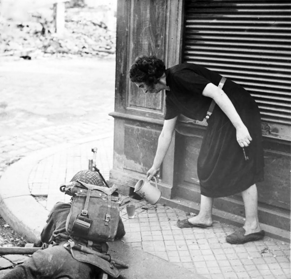 Француженка наливает британскому солдату чашку чая во время боевых действий, после высадки союзников в Нормандии, 1944 г.