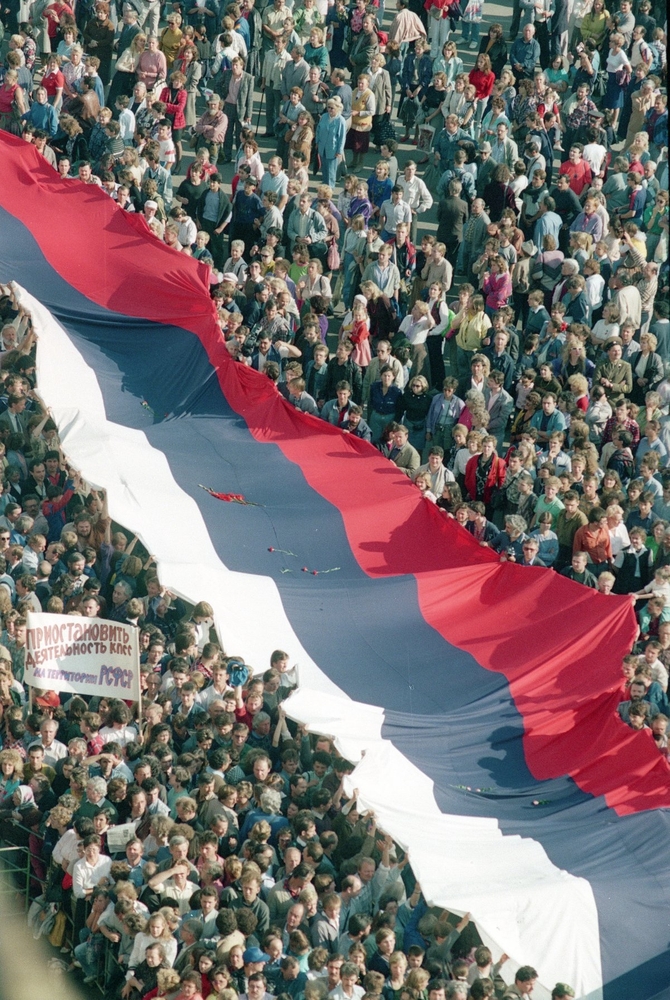 Несколько тысяч человек несут российский флаг в августе 1991 года.