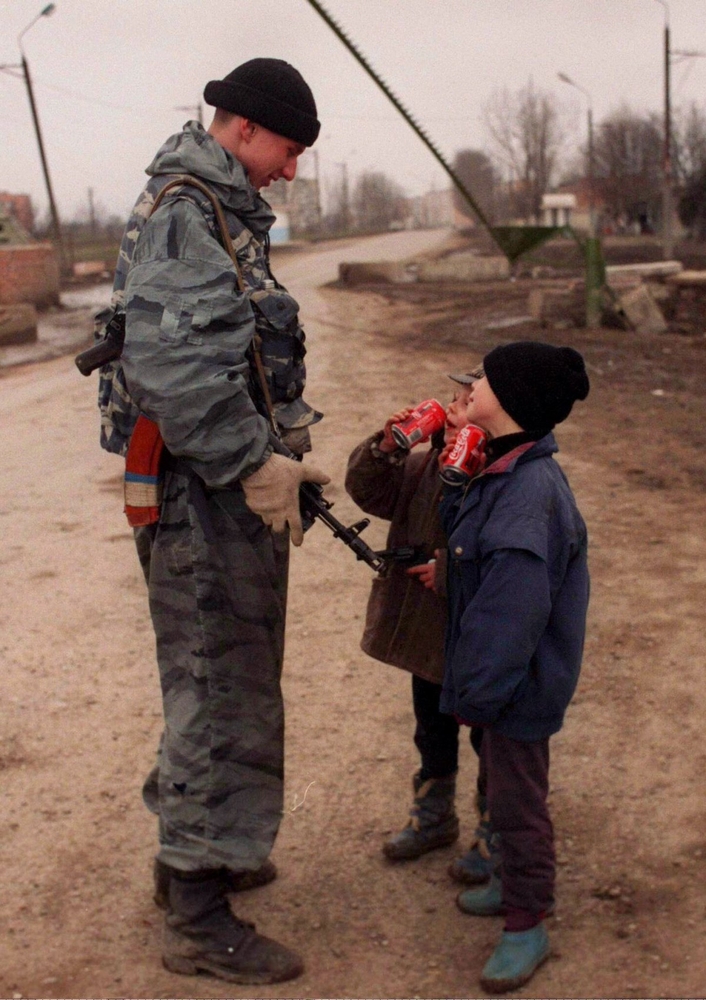 Солдат разговаривает с детьми неподалеку от Грозного, март 1996 года.