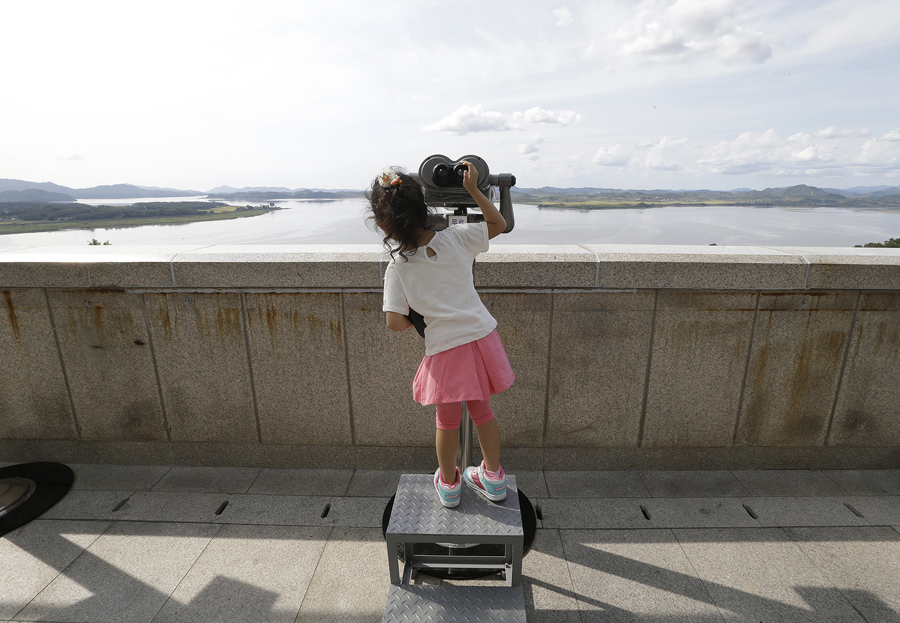 Южнокорейская девочка рассматривает северокорейскую территорию, 13 сентября 2016 года.