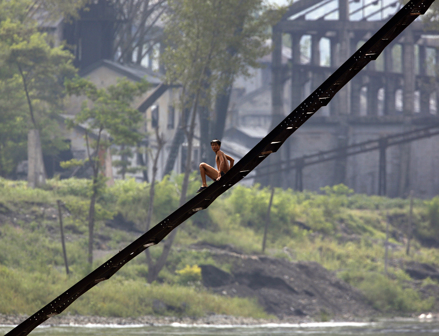 Мужчина спускается по лестнице заброшенной фабрики вдоль берега реки Ялу близ северокорейского города Кинг Чэн, 12 сентября 2008 года.