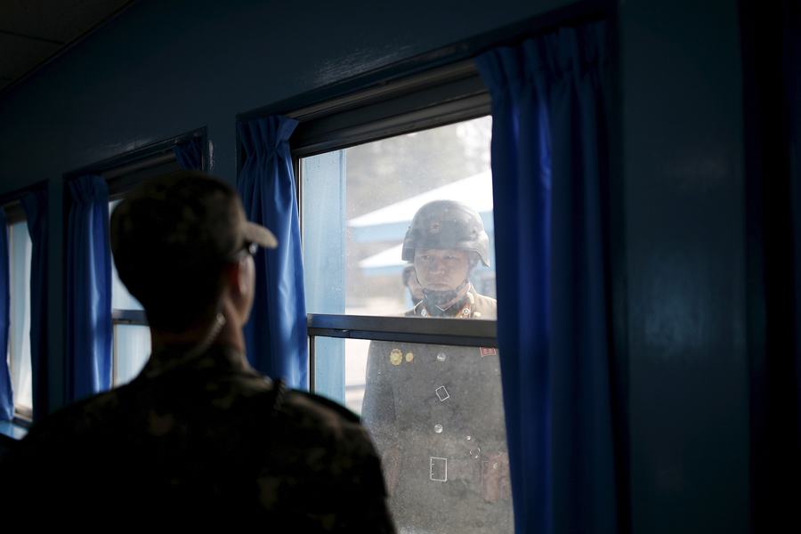 Север (справа) и южнокорейские солдаты смотрят друг на друга через окно конференц - зала в Организации Объединенных Наций , Южная Корея, 30 марта 2016 года.