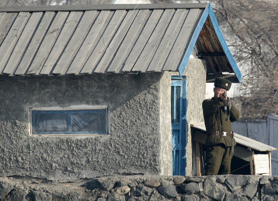 Северокорейский пограничник направляет свое оружие в сторону фотографа на берегу реки Ялу близ северокорейского города Хесане, 1 декабря 2008 года.