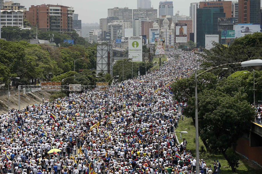 Тысячи антиправительственных демонстрантов маршеруют по шоссе в Каракасе, Венесуэла, 19 апреля 2017. Противники президента Николаса Мадуро призвали венесуэльцев выйти на улицы, чтобы выступить против лидера социалистов.