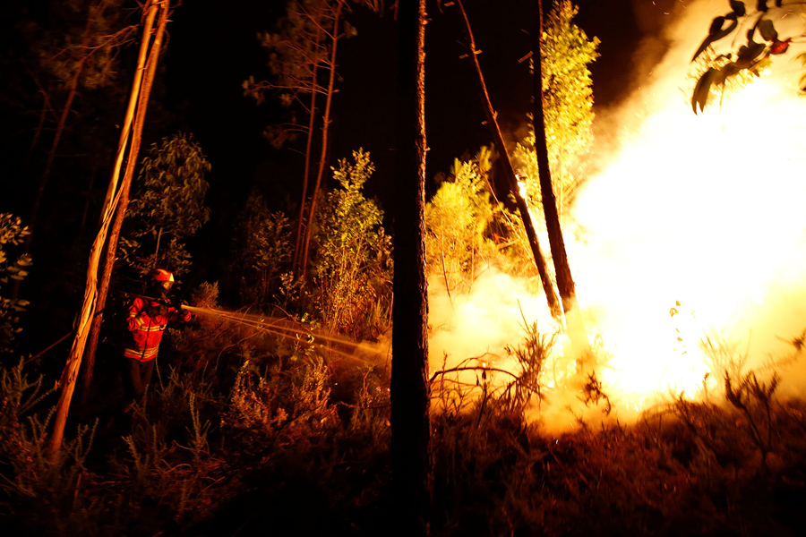 Пожарные работают, чтобы потушить лесной пожар возле Bouca, в центральной Португалии, 18 июня, 2017.