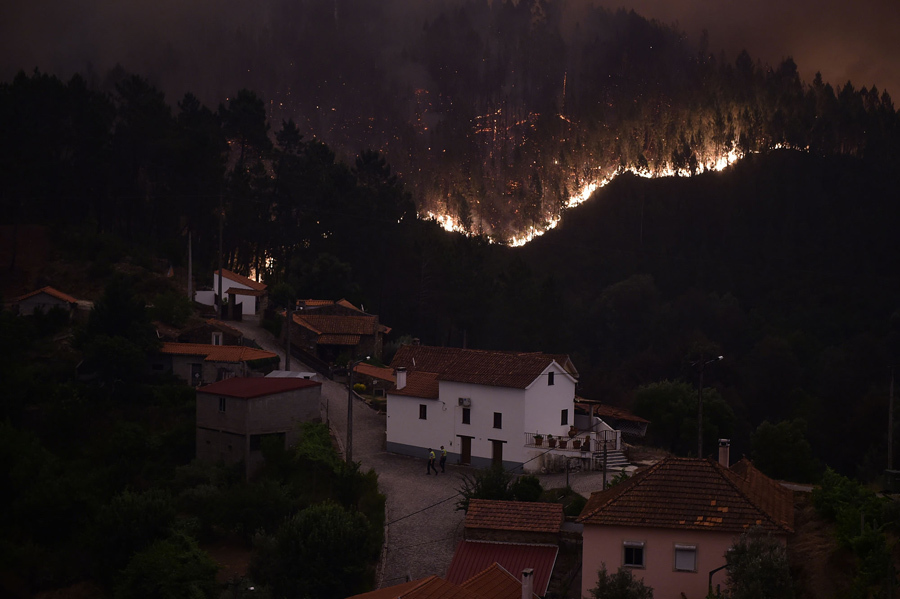 Пламя и дым из-за лесного пожара в районе сел Mega Fundeira, Португалия, 18 июня 2017 года.