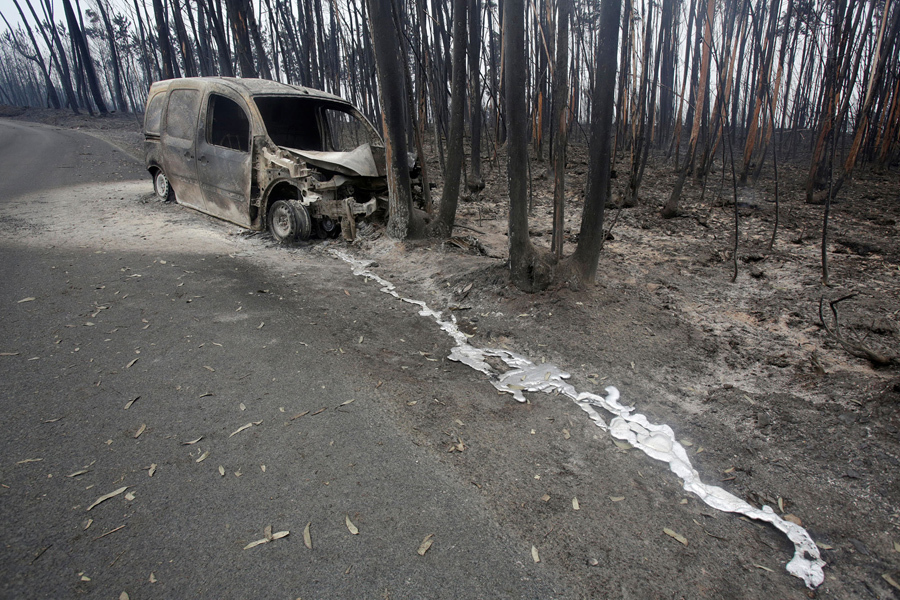 Сожженный фургон и деревья, после лесного пожара за пределами Pedrogao Grande, Португалия, 19 июня, 2017.