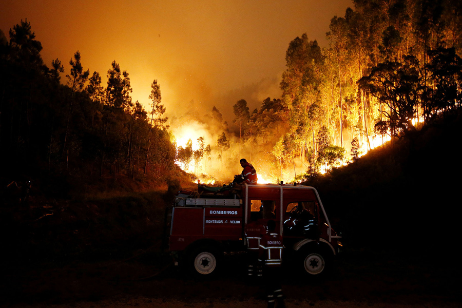 Пожарные работают, чтобы потушить лесной пожар возле Bouca, в центральной Португалии, 18 июня, 2017.