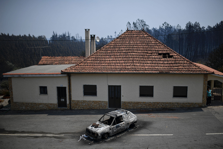 Сожженный автомобиль перед домом, после пожара в Figueiro dos Vinhos.