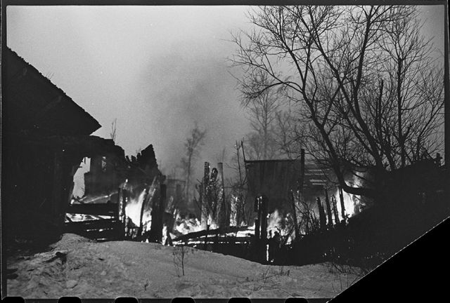 На путях отступления немцев в районе Гатчины горят подожженные гитлеровцами дома на Красной улице, переименованной немцами в Штутгартштрассе. Ленинградский фронт, 1943 год:
