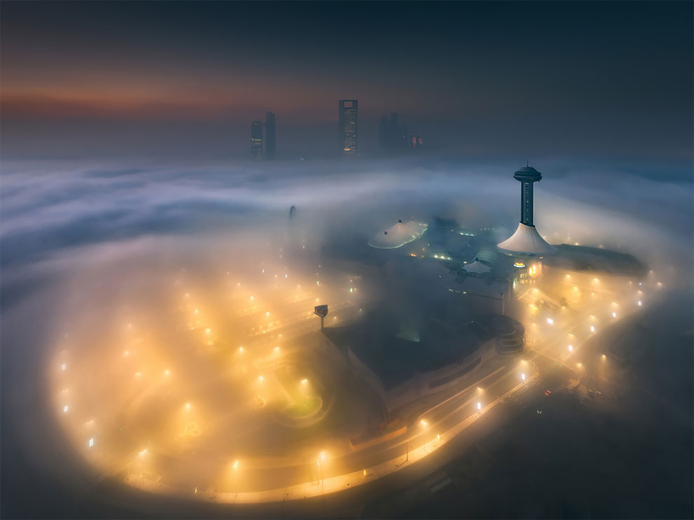 Возвышающиеся над туманом небоскребы в Абу-Даби