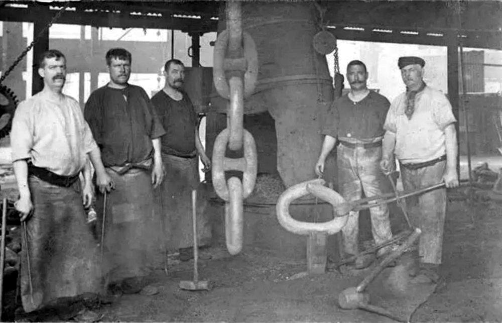 Рабочие стоят рядом с цепью, использованной для якоря Титаника в 1910 году