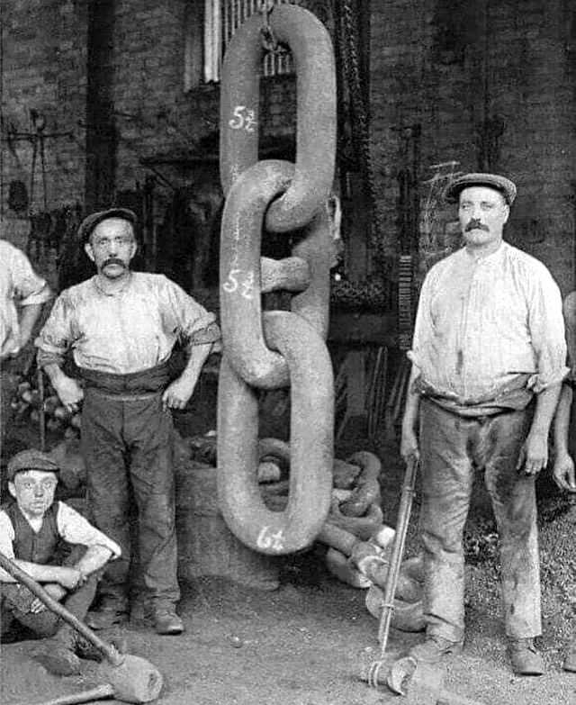 Рабочие стоят рядом с цепью, использованной для якоря Титаника в 1910 году